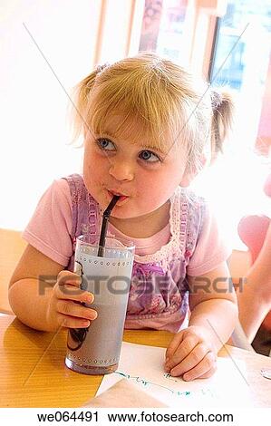 3 year old girl sitting in a cafe drinking her drink through a straw, smiling off camera View Large Photo Image Stock Image - 3 year old girl sitting in a cafe drinking her drink through a straw, smiling off camera. Fotosearch