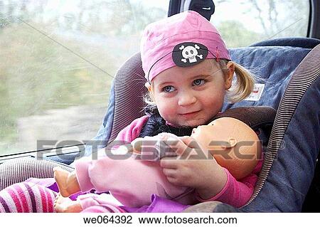 3 year old girl, sitting in her carseat, holding her doll, goinig to a pirate party View Large Photo Image Stock Image - 3 year old girl, sitting in her carseat, holding her doll, goinig to a pirate party. Fotosearch