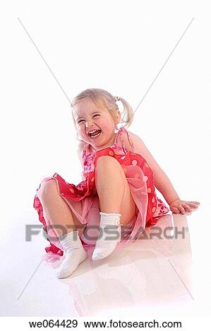 3 Year old girl sitting with legs crossed on the studio floor laughing off camera View Large Photo Image Stock Photo - 3 Year old girl sitting with legs crossed on the studio floor laughing off camera. Fotosearch