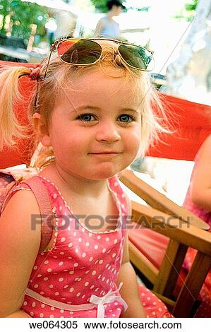 3 year old girl smiling into camera, wearing sunglasses on her head in an outside cafe View Large Photo Image Stock Photography - 3 year old girl smiling into camera, wearing sunglasses on her head in an outside cafe. Fotosearch
