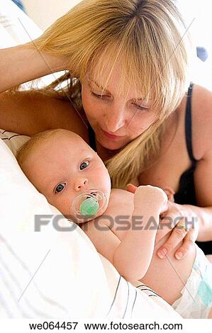 35 year old mother, looking at her 8 week old baby, lying on the bed View Large Photo Image Stock Photo - 35 year old mother, looking at her 8 week old baby, lying on the bed. Fotosearch
