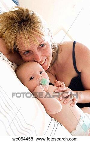 35 year old mother, lying on the bed with eight 8 week old baby View Large Photo Image Stock Photo - 35 year old mother, lying on the bed with eight 8 week old baby. Fotosearch