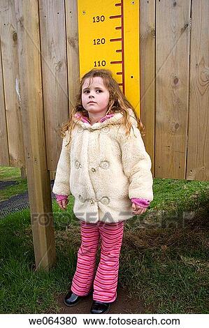 4 year old girl measuring herself against a height chart View Large Photo Image Stock Image - 4 year old girl measuring herself against a height chart. Fotosearch