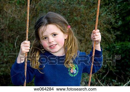 4 year old girl swinging outside, wearing school uniform, with bunches View Large Photo Image Picture - 4 year old girl swinging outside, wearing school uniform, with bunches. Fotosearch