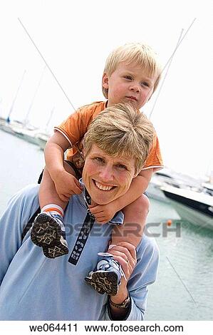40 year old woman with her son on her shoulders smiling into camera View Large Photo Image Stock Image - 40 year old woman with her son on her shoulders smiling into camera. Fotosearch