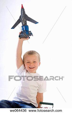 5 Year old boy holding a toy aeroplane up in the air smiling into camera View Large Photo Image Stock Photograph - 5 Year old boy holding a toy aeroplane up in the air smiling into camera. Fotosearch