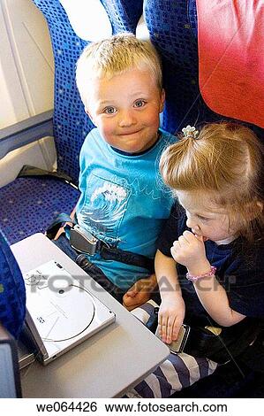 5 year old boy with little sister sitting on plane watching a dvd player View Large Photo Image Stock Photograph - 5 year old boy with little sister sitting on plane watching a dvd player. Fotosearch