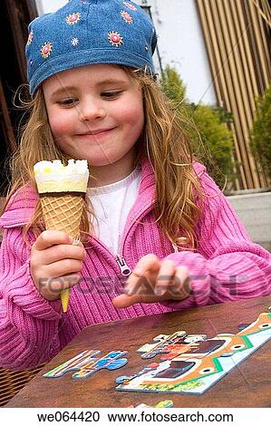 5 year old girl sitting eating an ice cream, smiling at it View Large Photo Image Stock Image - 5 year old girl sitting eating an ice cream, smiling at it. Fotosearch