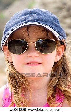 5 year old girl wearing a baseball cap and her daddys sunglasses View Large Photo Image Stock Photo - 5 year old girl wearing a baseball cap and her daddys sunglasses. Fotosearch
