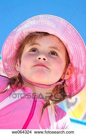 5 year old girl wearing a big sunhat at the pool smiling up to the sun View Large Photo Image Picture - 5 year old girl wearing a big sunhat at the pool smiling up to the sun. Fotosearch