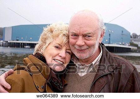 70 year old couple smiling, three quarter length shot, cuddling View Large Photo Image Stock Photo - 70 year old couple smiling, three quarter length shot, cuddling. Fotosearch