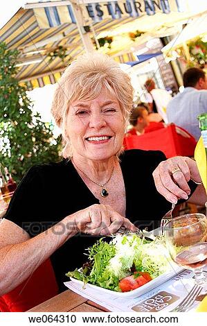 70 year old grandmother eating out in a cafe, smiling into camera View Large Photo Image Stock Image - 70 year old grandmother eating out in a cafe, smiling into camera. Fotosearch