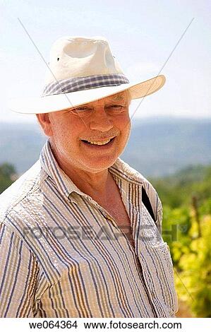 72 year old man outside, in a vine yard, wearing a sun hat, smiling into camera View Large Photo Image Picture - 72 year old man outside, in a vine yard, wearing a sun hat, smiling into camera. Fotosearch