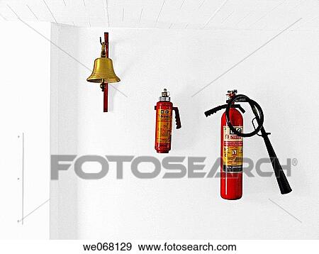 Stock Photo - A cylinder with fire resistant gas and a bell hanged on a wall in a factory. Pune, Maharashtra, India.. Fotosearch