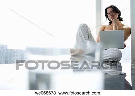 Stock Photo - absorbed, black hair, barefoot, 20's. Fotosearch
