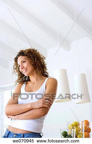 Stock Photography - Arms crossed, brunette, at-home, arms folded, 20's. Fotosearch