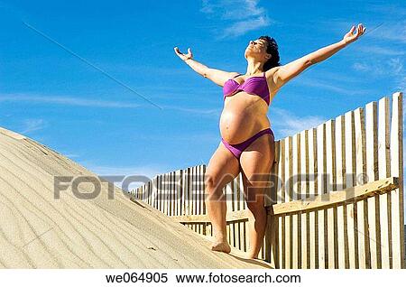 Stock Photography - Arms open, belly, beach, 30's. Fotosearch