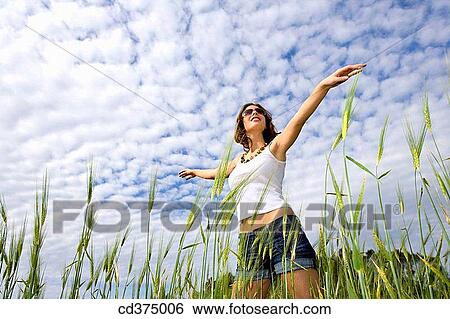Stock Photograph - Arms open, carefree, brunette, 20's. Fotosearch