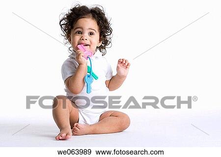 Stock Photo - baby, barefoot, bite, biting, Brown eye, brunette. Fotosearch