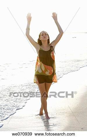 Stock Photo - barefoot, calm, beach, Arms raised. Fotosearch