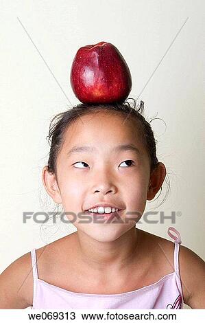 child, aiming, balance, Asian, apple, aim View Large Photo Image Stock Image - child, aiming, balance, Asian, apple, aim. Fotosearch