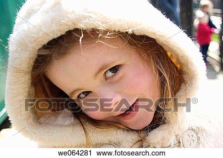 Stock Image - close up headshot of a 4 year old girl, looking coyly into camera. Fotosearch