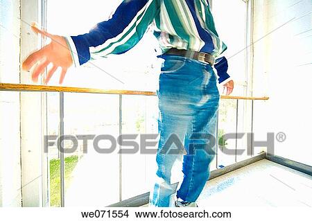 Close-up of a man standing in front of a large window View Large Photo Image Picture - Close-up of a man standing in front of a large window. Fotosearch