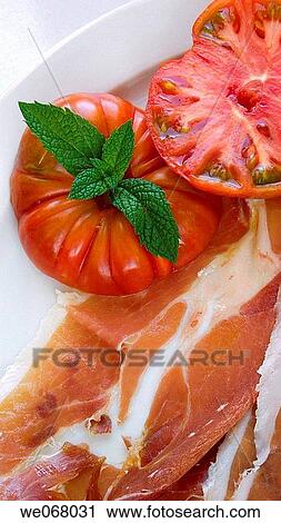 Stock Image - Cured ham with tomato and mint. Fotosearch