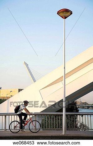 Cyclist crossing Barqueta bridge and Alamillo bridge by Santiago Calatrava in background, Sevilla. Andalucia, Spain View Large Photo Image Stock Image - Cyclist crossing Barqueta bridge and Alamillo bridge by Santiago Calatrava in background, Sevilla. Andalucia, Spain. Fotosearch