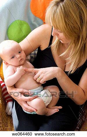 eight week old baby sitting on his mothers knee View Large Photo Image Stock Image - eight week old baby sitting on his mothers knee. Fotosearch