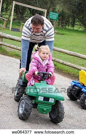 father pushing his 3 year old daUGHTER, on a pretend tracter View Large Photo Image Stock Photo - father pushing his 3 year old daUGHTER, on a pretend tracter. Fotosearch