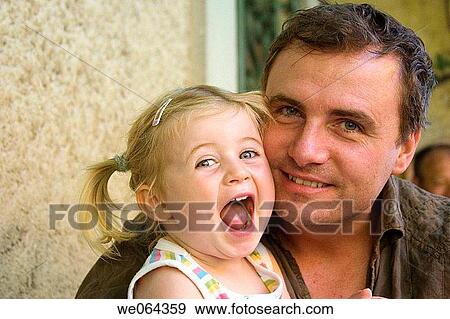 father sitting with his 3 year old daughter, smiling into camera View Large Photo Image Stock Photo - father sitting with his 3 year old daughter, smiling into camera. Fotosearch