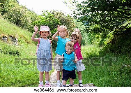 group of four children on a walk in the counryside standing waving into camera View Large Photo Image Stock Photography - group of four children on a walk in the counryside standing waving into camera. Fotosearch