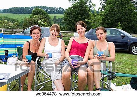 group of four women on a camping trip sitting together on deck chairs View Large Photo Image Stock Photo - group of four women on a camping trip sitting together on deck chairs. Fotosearch