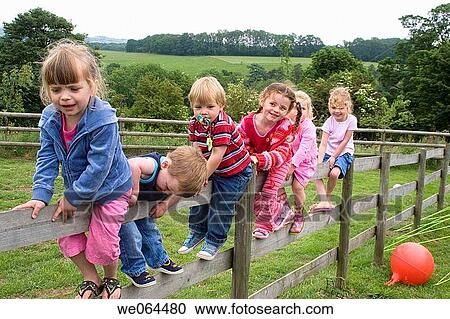 group of six young children playing on a fence smiling into camera View Large Photo Image Stock Image - group of six young children playing on a fence smiling into camera. Fotosearch