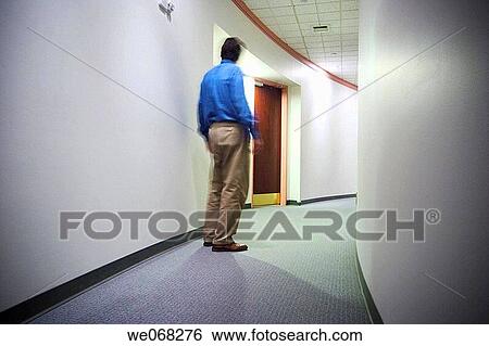 Man in the hallway of an office building View Large Photo Image Stock Photograph - Man in the hallway of an office building. Fotosearch