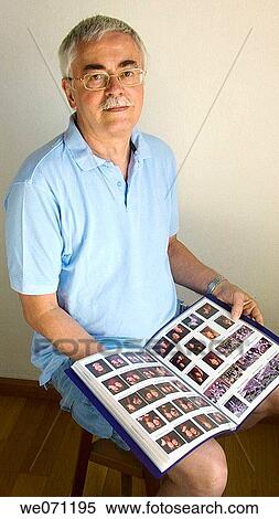 Stock Photography - Man looking at pictures. Fotosearch