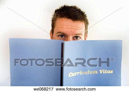 Stock Photo - Man looking up from behind Curriculum Vitae folder. Fotosearch