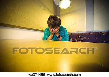 Stock Photography - Man sitting at a cafeteria table. Fotosearch