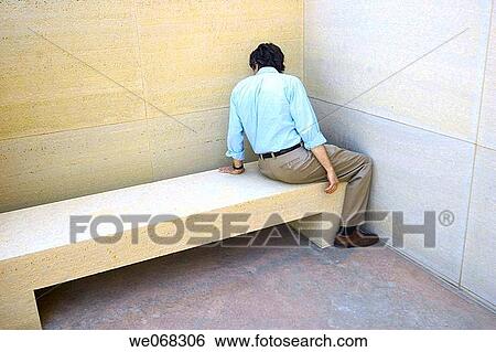 Stock Photograph - Man sitting on a concrete bench. Fotosearch