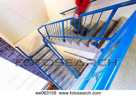 Stock Photo - Man walking down a stairwell in an office building. Fotosearch