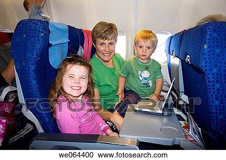 mother and two children, sitting an a plane watching a dvd player, smiling into camera View Large Photo Image Stock Image - mother and two children, sitting an a plane watching a dvd player, smiling into camera. Fotosearch