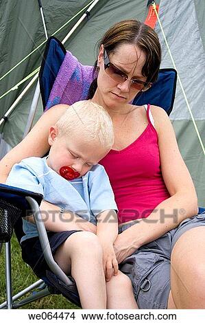 mother and two year old son sitting outside the babys asleep, on a camping trip View Large Photo Image Picture - mother and two year old son sitting outside the babys asleep, on a camping trip. Fotosearch