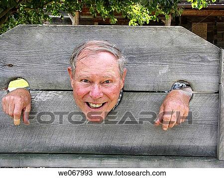 Older man pretends to be locked in stocks at a pioneer park in Kentucky, USA. View Large Photo Image Stock Image - Older man pretends to be locked in stocks at a pioneer park in Kentucky, USA.. Fotosearch
