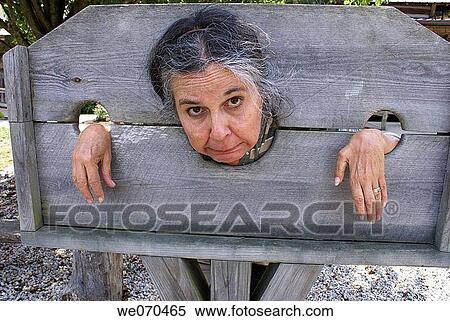 Older woman trapped in stocks at a pioneer park in Kentucky, USA. View Large Photo Image Stock Photography - Older woman trapped in stocks at a pioneer park in Kentucky, USA.. Fotosearch