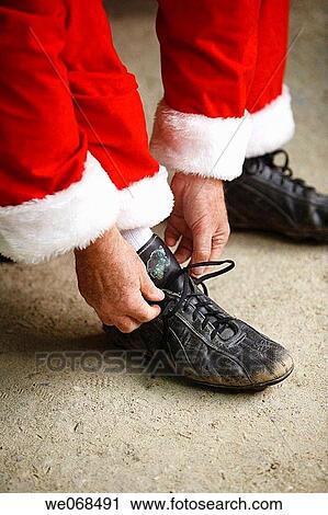 Santa Putting On Baseball Shoes Stock Image We068491 Fotosearch