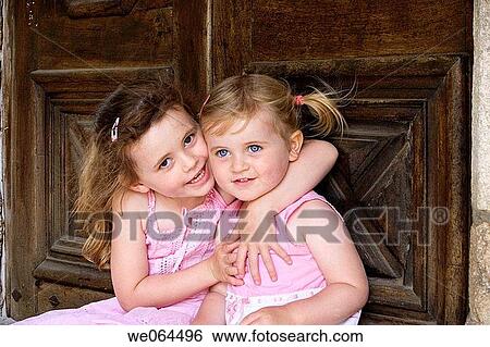 sisters, 2 and 5 cuddling smiling into camera View Large Photo Image Stock Photograph - sisters, 2 and 5 cuddling smiling into camera. Fotosearch