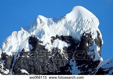 Stock Photography - Sunrise on snow-capped mountains in the magnificent Lemaire Channel, Antarctica.. Fotosearch