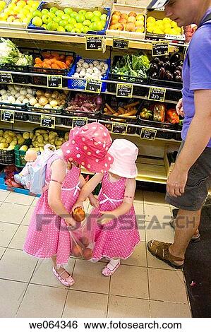 the back of 2 sisters age 3 aAND 5, putting shopping in a bag at the supermarket with their father View Large Photo Image Stock Photograph - the back of 2 sisters age 3 aAND 5, putting shopping in a bag at the supermarket with their father. Fotosearch