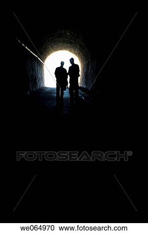 Two persons coming out from an old tunnel View Large Photo Image Stock Image - Two persons coming out from an old tunnel. Fotosearch